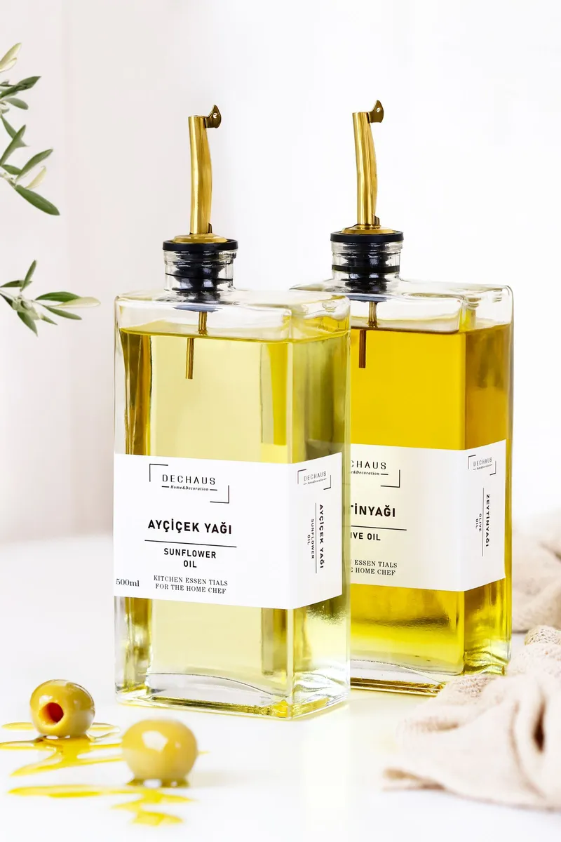 Botellas de vidrio oscuro con aceite de oliva alineadas sobre una superficie de madera