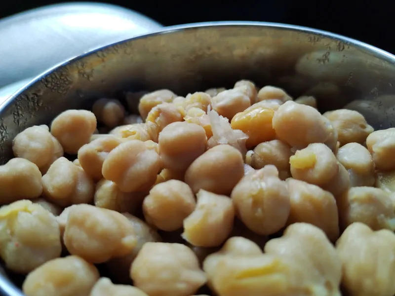 Garbanzos cocidos en un bol metálico, listos para repartir en raciones